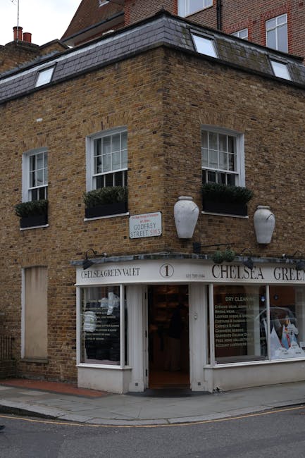 A three-storey brick building with a retail shop on the ground floor, identified as Chelsea Green Valet, situated on a street corner in an urban area. The brick exterior features a warm, earthy tone w